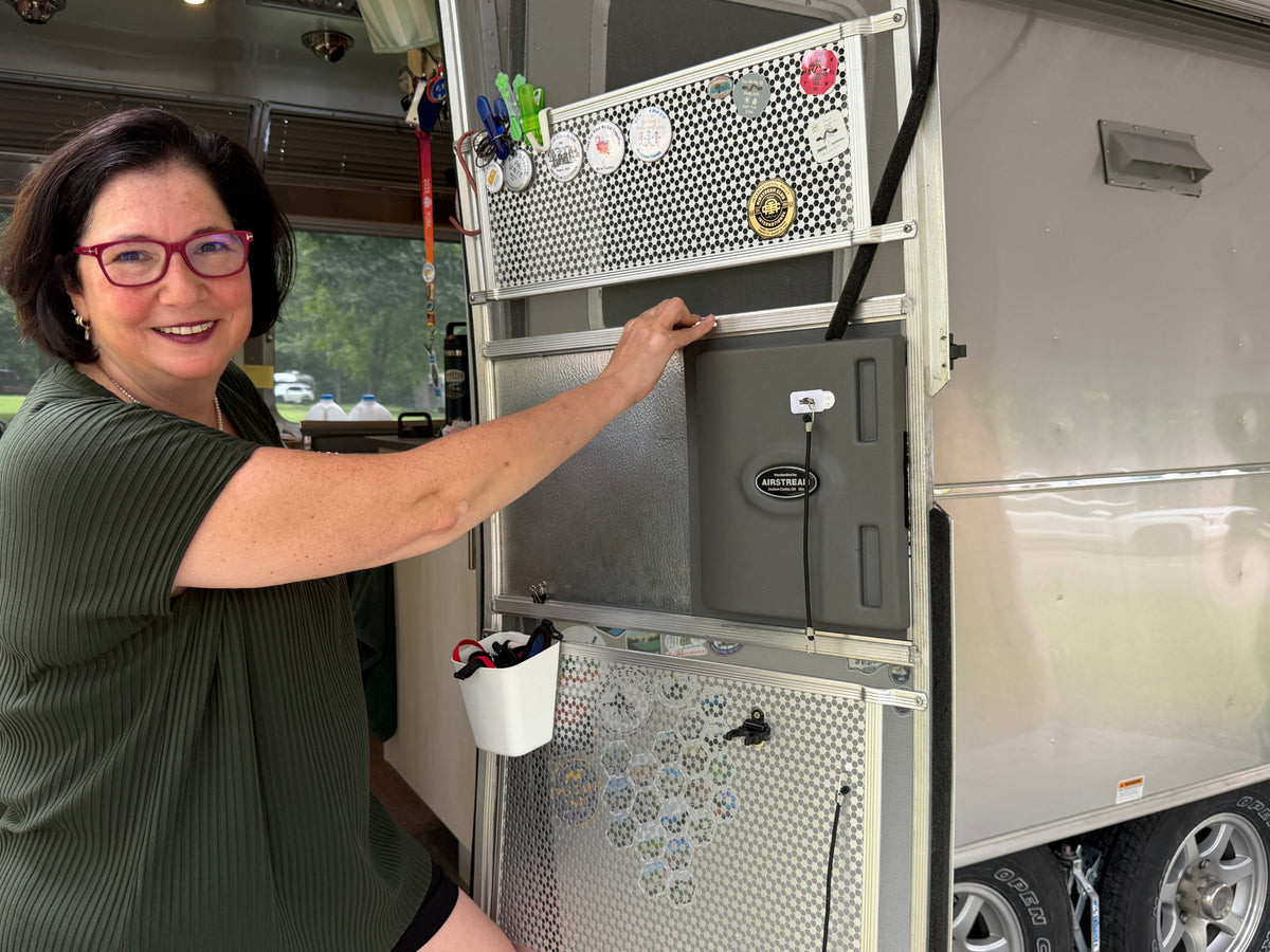Jennifer Eggers smiling beside her Airstream doorway